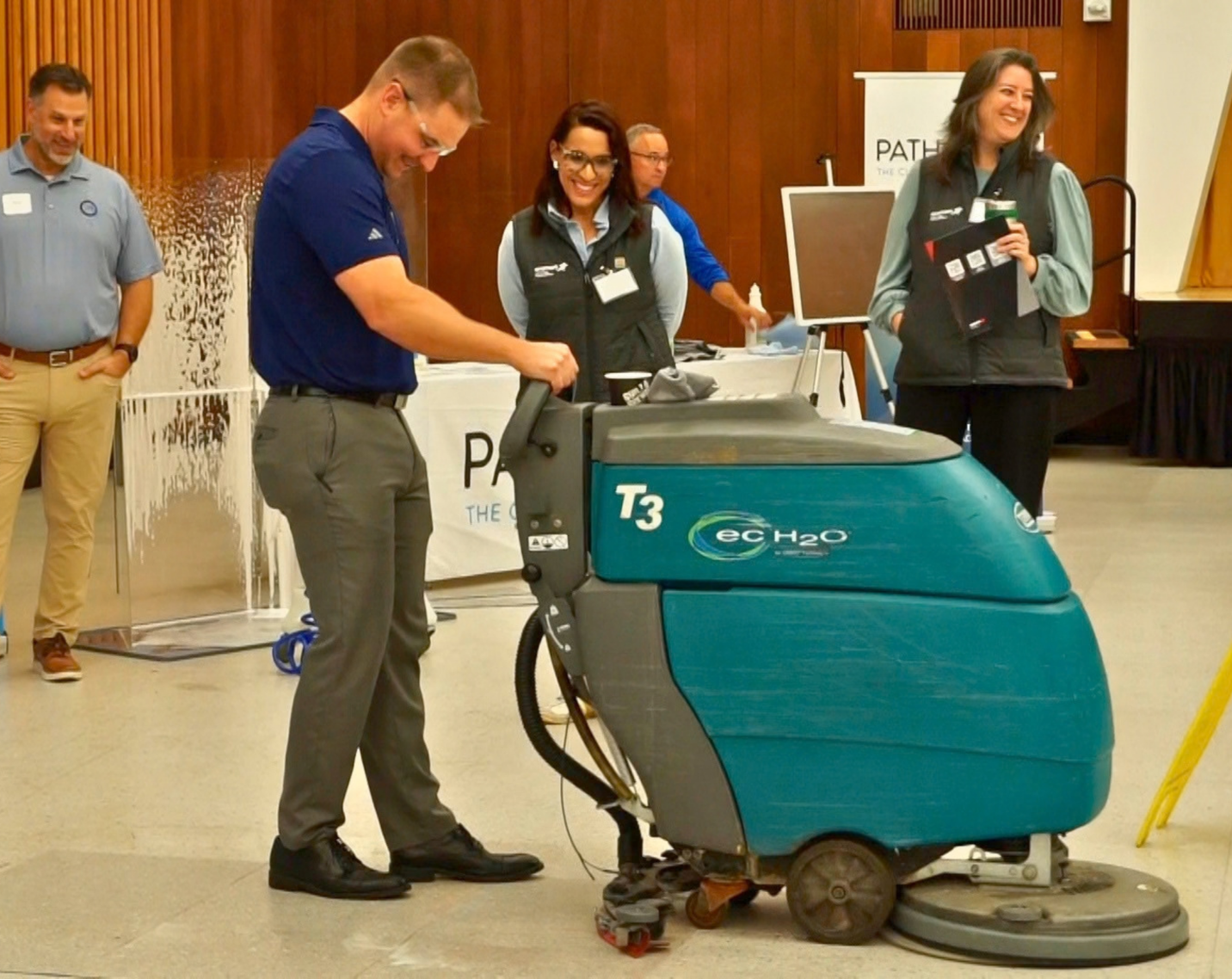 A representative from PathoSans demonstrates a floor-cleaning solution during the Facilities Management Innovation Forum.